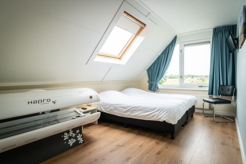 Lichte slaapkamer met dakraam in Villa 6 personen, De Koog Texel, met prachtig uitzicht op de omgeving.