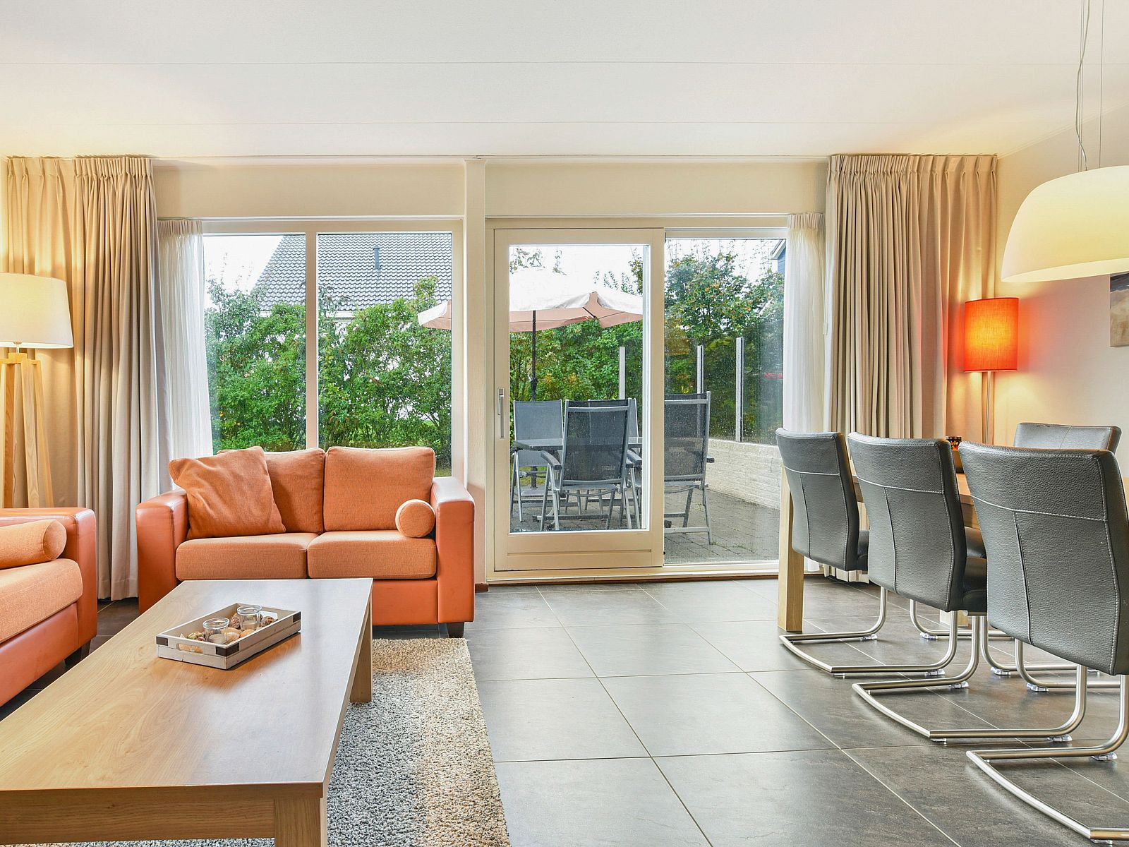 Ruim terras met parasol bij Beach Park Texel 6-persoons villa, De Koog, ideaal voor buiten dineren.