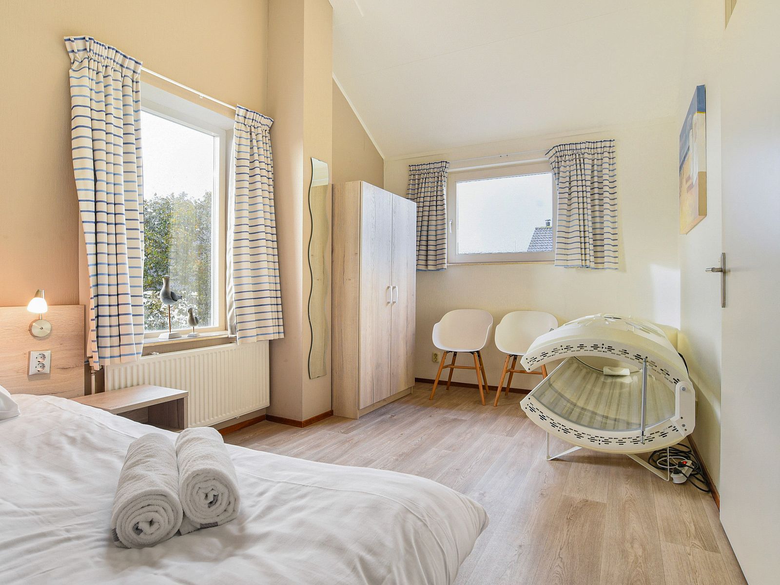 Slaapkamer met tweepersoonsbed in Beach Park Texel 6-persoons villa, De Koog, met uitzicht op de tuin.