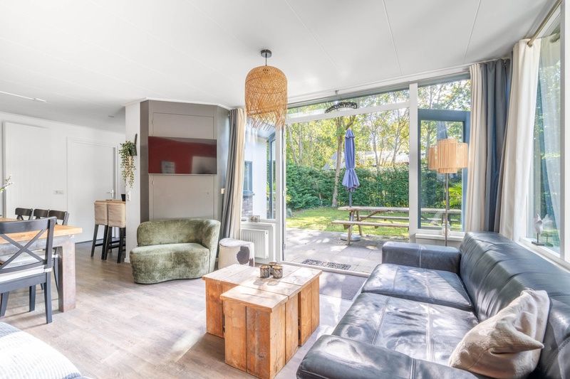 Heller Wohnraum im Bungalow De Nagtegaal 21, Bungalowpark De Nagtegaal, De Koog, Texel mit Zugang zur Terrasse.