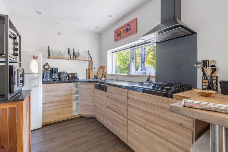 Moderne Kueche im Bungalow De Nagtegaal 21, Bungalowpark De Nagtegaal, De Koog, Texel mit Holzschraenken und Einbaugeraeten.