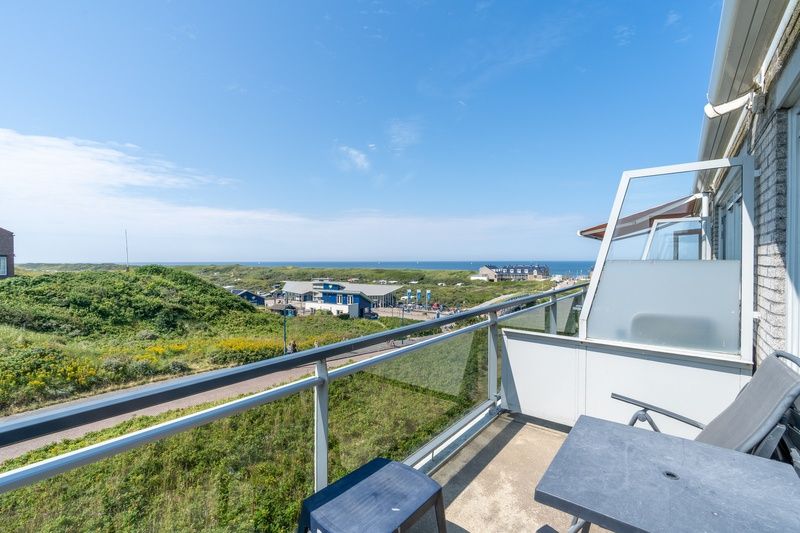Balcony of Apartment Juliana 094 Island and Sea View, De Koog, Texel with panoramic views of sea and dunes.