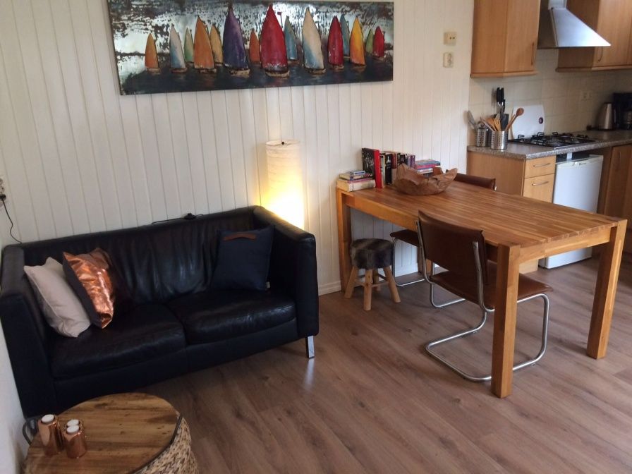 Gezellige woonkamer van Zomerhuisje Plevierstraat 12 in De Koog, Texel, met comfortabele zithoek en eethoek, ideaal voor een ontspannen verblijf.