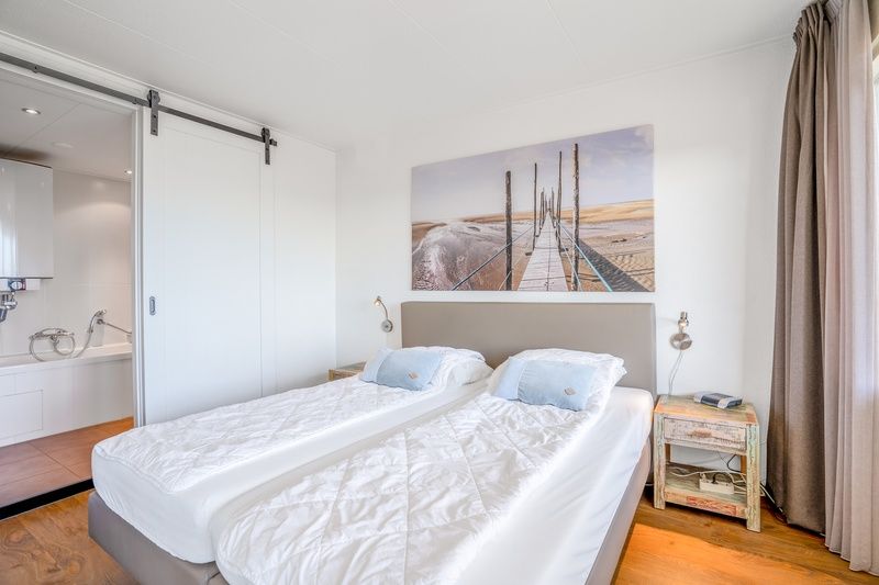 Ruime slaapkamer in Appartement Juliana 122 Eilandzicht, De Koog, Texel met toegang tot balkon en prachtig uitzicht.