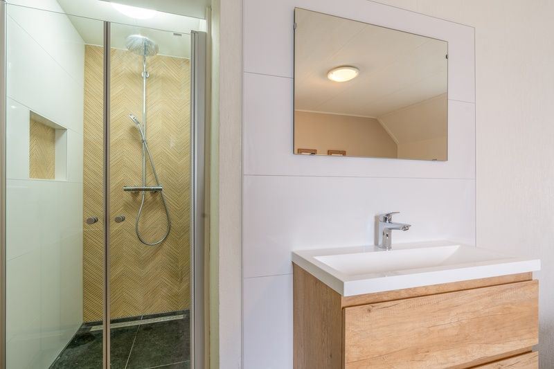 Stijlvolle badkamer in Vakantiehuis Kamperfoelie 47 De Koog Texel met moderne douche.