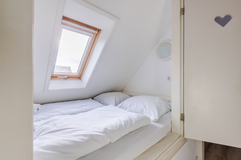 Gemuetliches Interieur des Bungalows T6AB Comfort in De Koog, Texel, mit verspielten Schranktueren und Holzboden fuer eine warme Atmosphaere.