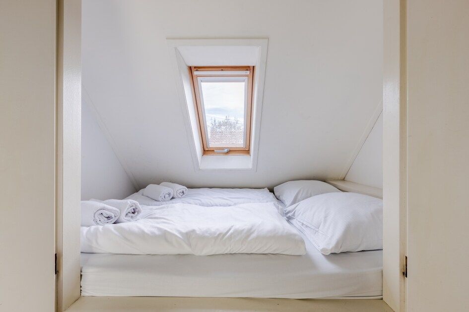 Gemuetliches Schlafzimmer im Bungalow T6AB Comfort, De Koog, Texel. Helle Einrichtung mit zwei Betten und Holzboden, ideal zum Entspannen.