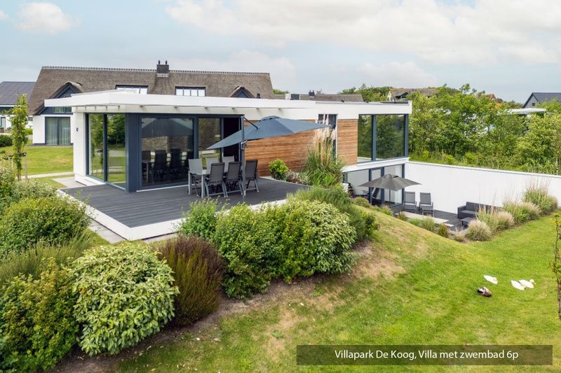 Offene Kueche und Wohnzimmer in luxurioeser Familienvilla mit Schwimmbad, De Koog Texel. Moderne Einrichtung mit Blick auf den Garten.