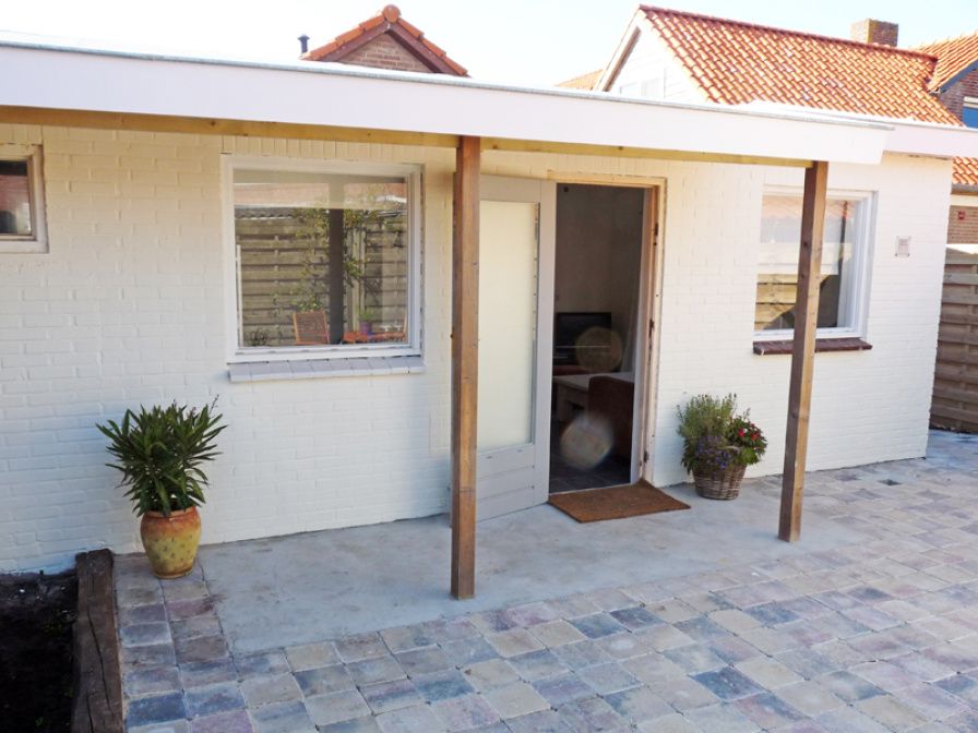 Buitenkant van Zomerhuisje Schoo in De Koog, Texel, vakantiehuis met overdekte veranda.