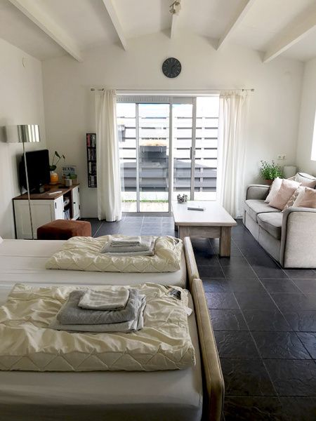 Lichte binnenruimte van Zomerhuisje Schoo in De Koog, Texel, met comfortabele zithoek.