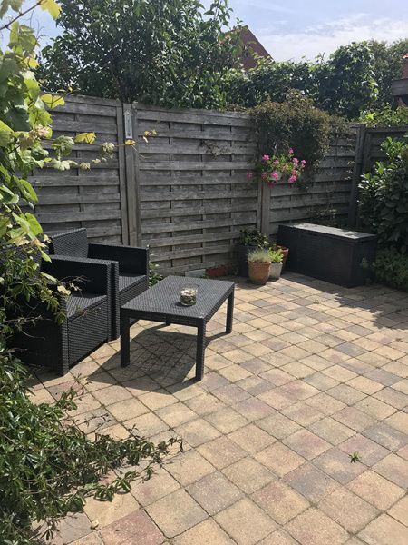 Priveterras van Zomerhuisje Schoo in De Koog, Texel, omgeven door groene natuur.