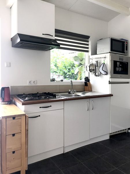 Volledig uitgeruste keuken in Zomerhuisje Schoo, De Koog, Texel, met uitzicht op de tuin.