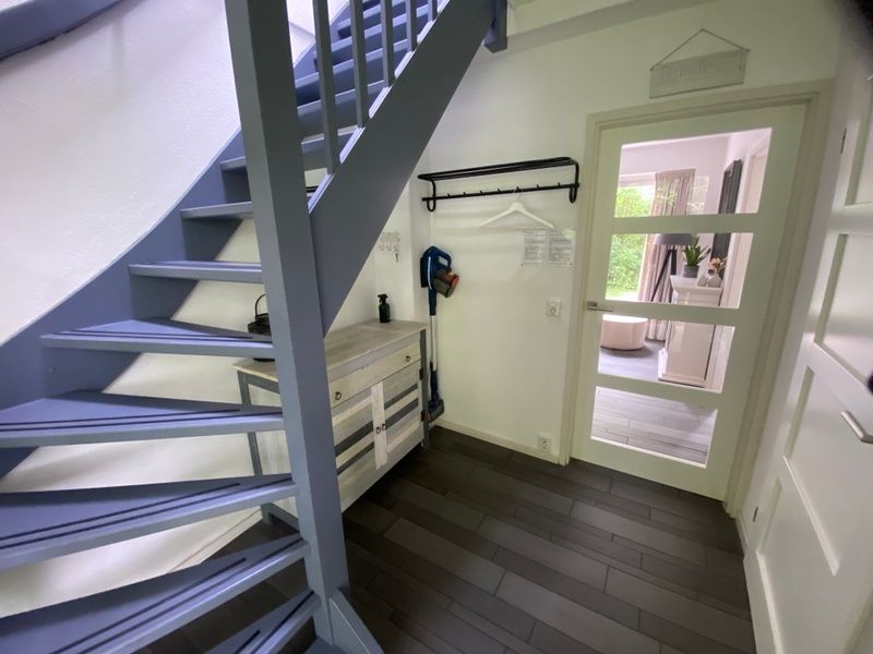 Stilvolles Wohnzimmer des Ferienhauses Hoog Koog 18 in De Koog, Texel, mit Blick auf den Garten im Bungalowpark Hoog Koog.