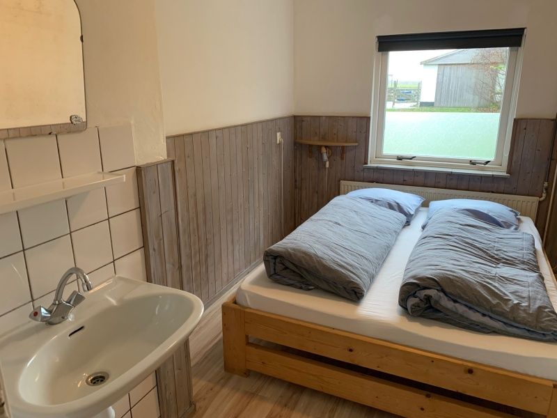 Comfortabele slaapkamer in Vakantiehuis 0386 De Koog Texel, ideaal voor rust en ontspanning op de Waddeneilanden.