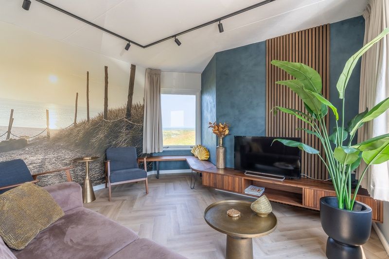 Spacious living room of Apartment Juliana 120 Eilandzicht, De Koog, Texel with beach decorations and comfortable chairs.