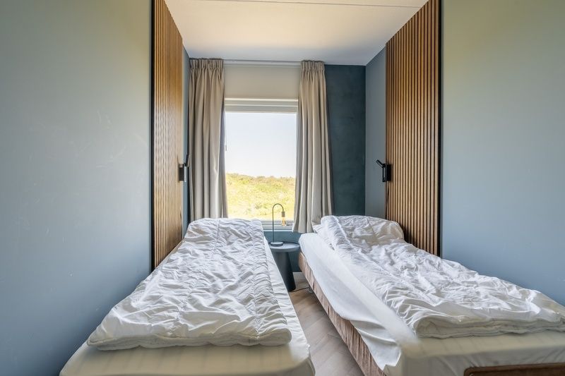 Cozy bedroom in Apartment Juliana 120 Eilandzicht, De Koog, Texel with two single beds and landscape views.