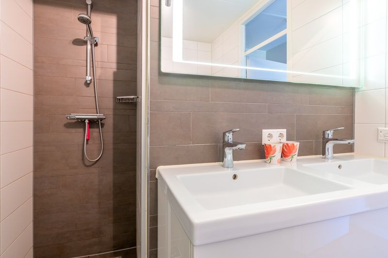 Modern bathroom in Apartment Juliana 120 Eilandzicht, De Koog, Texel with walk-in shower and double sink.