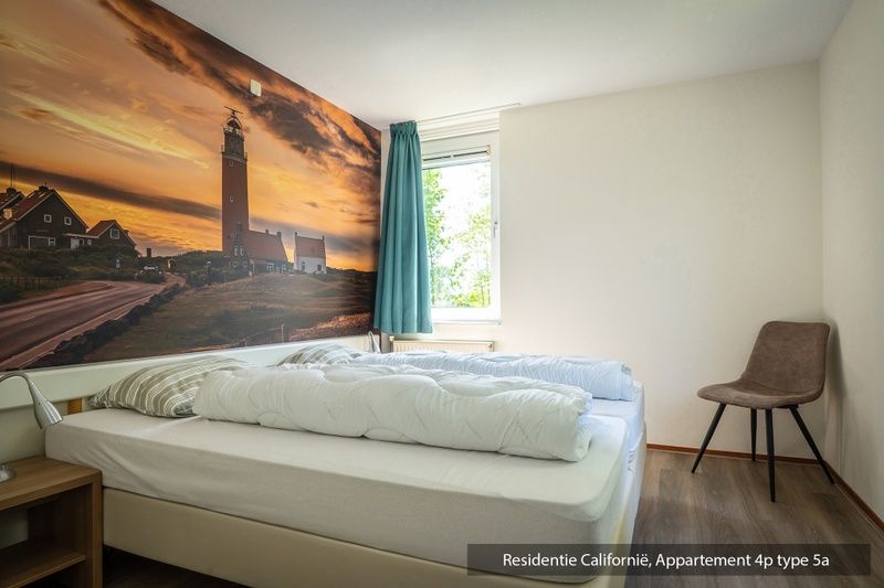 Lichte woonkamer in Type 5A vakantiewoning, De Koog, Texel met groot raam en uitzicht.