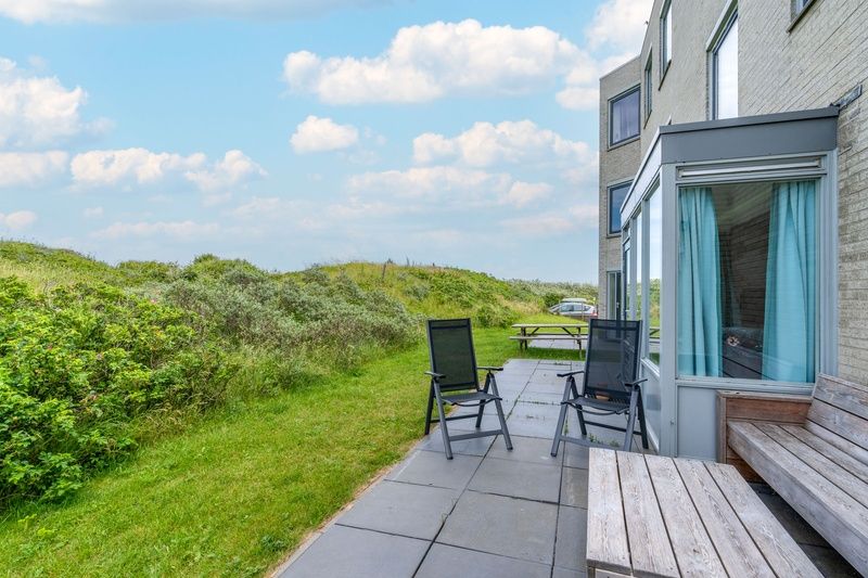 Sitzgelegenheiten im Freien auf der Terrasse von Apartment Juliana 068 Island and Sea View, De Koog, Texel mit Blick auf die Duenen.