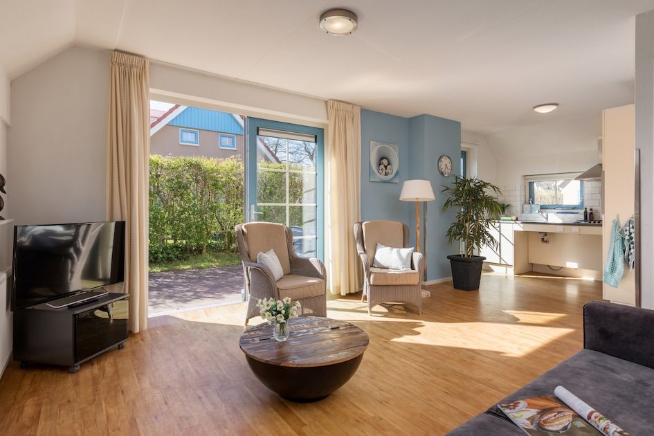 Bright living room of bungalow T6AM in De Koog, Texel, with comfortable interior and garden view, ideal for relaxation.