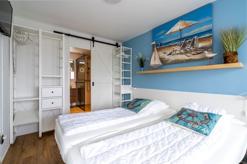 Stijlvolle slaapkamer in Appartement Juliana 076 Eilandzicht, De Koog, Texel met strandthema en comfortabele bedden.