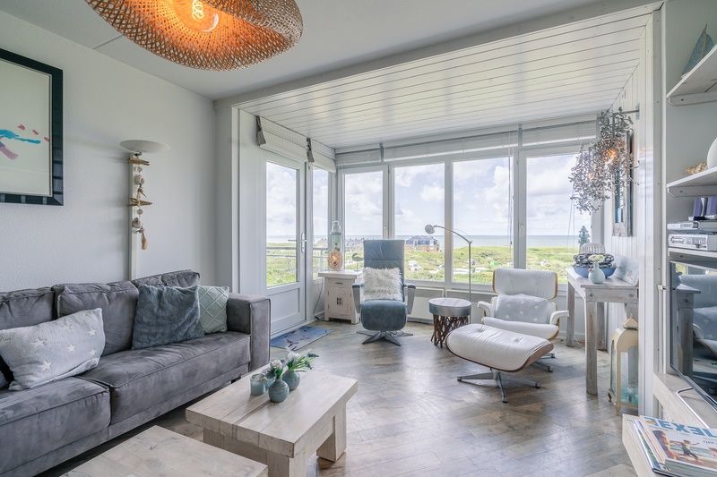 Gezellige woonkamer van Appartement Juliana 106 Zeezicht in De Koog, Texel met grote ramen en uitzicht op de natuur.