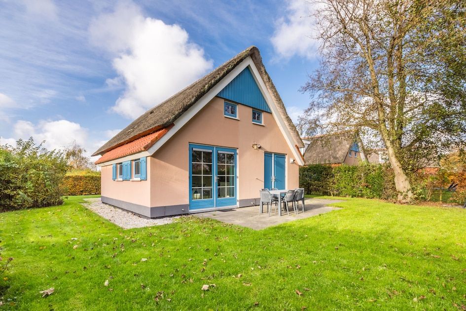 Bungalow T6AB in De Koog, Texel met rieten dak en terras in groene omgeving, ideaal voor een ontspannen vakantie op de Waddeneilanden.