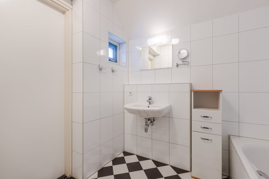Moderne badkamer in bungalow T6AB, De Koog, Texel met strakke witte tegels en een stijlvolle wastafel voor een comfortabel verblijf.