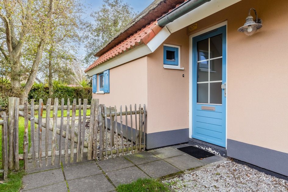 Geniet van het terras van bungalow T6AB in De Koog, Texel, omringd door groene natuur op de Waddeneilanden.