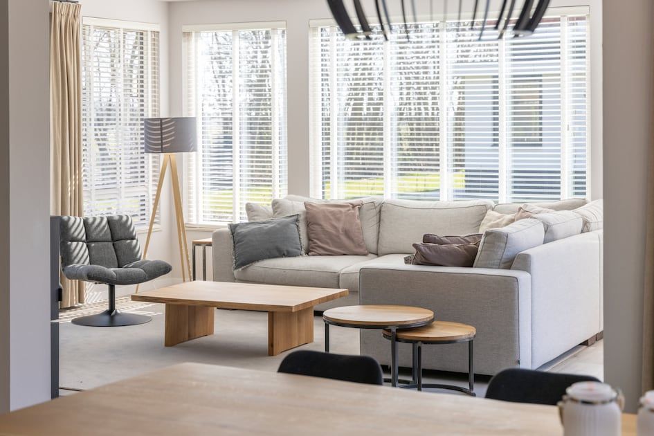 Stilvolles Wohnzimmer in Villa 8, einem Ferienhaus in De Koog, Texel. Gemuetliche Sitzecke mit Holzofen und Blick auf die Natur.