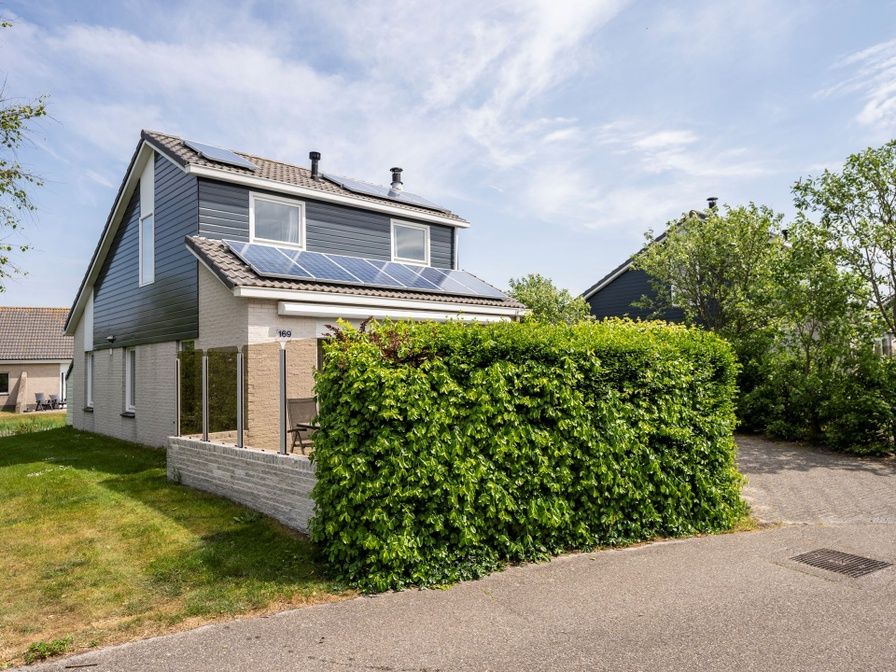 Vakantiehuis Stappeland 169 in De Koog, Texel met zonnige buitenkant en groene omgeving.