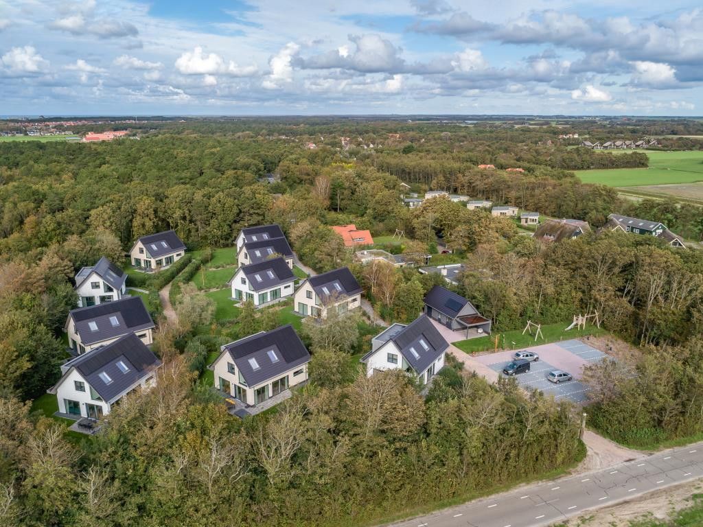 Omgeving van 39 - 16B Wulp - BLV in De Koog, Texel met meerdere vakantiehuizen en groen landschap.