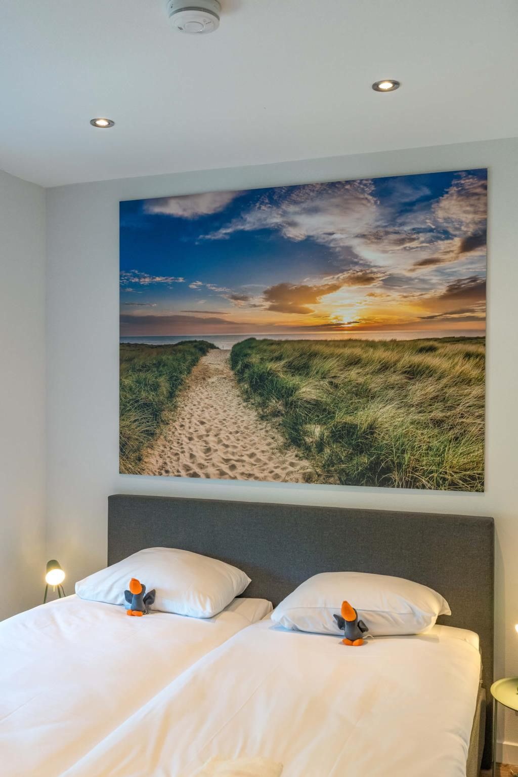 Slaapkamer in 39 - 16B Wulp - BLV, vakantiehuis in De Koog, Texel met kunst aan de muur.