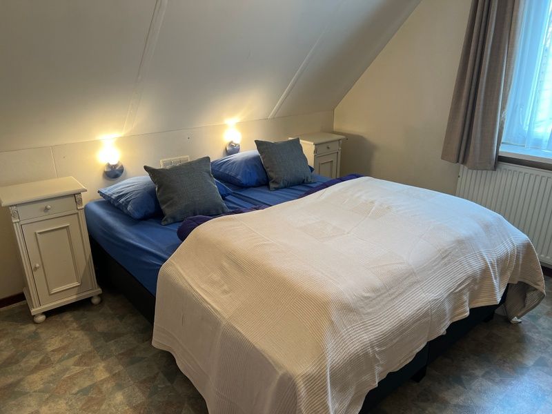 Ruime slaapkamer met tweepersoonsbed in Landgoed Springtij - Koetshuis 3, De Koog, Texel.
