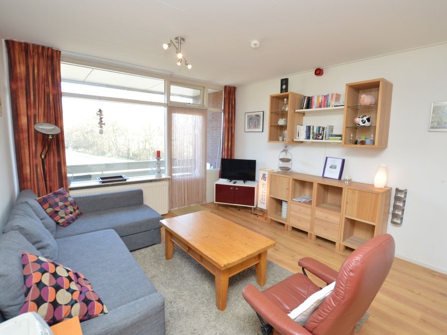 Gezellige woonkamer in Appartement Kerckeland 50, De Koog, Texel met comfortabele zithoek en uitzicht op de natuur.