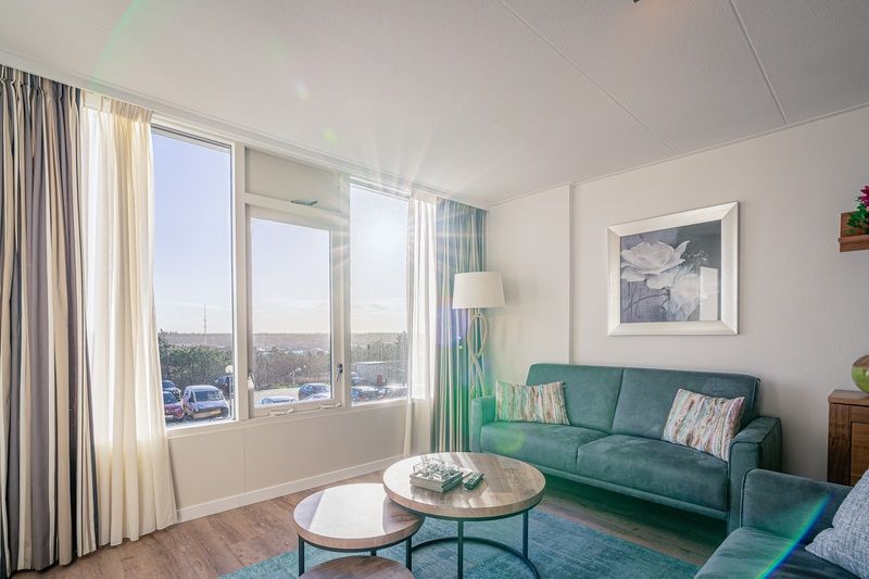 Sonniges Wohnzimmer von Apartment Juliana 124 Eilandzicht, De Koog, Texel mit grossen Fenstern und Aussicht.