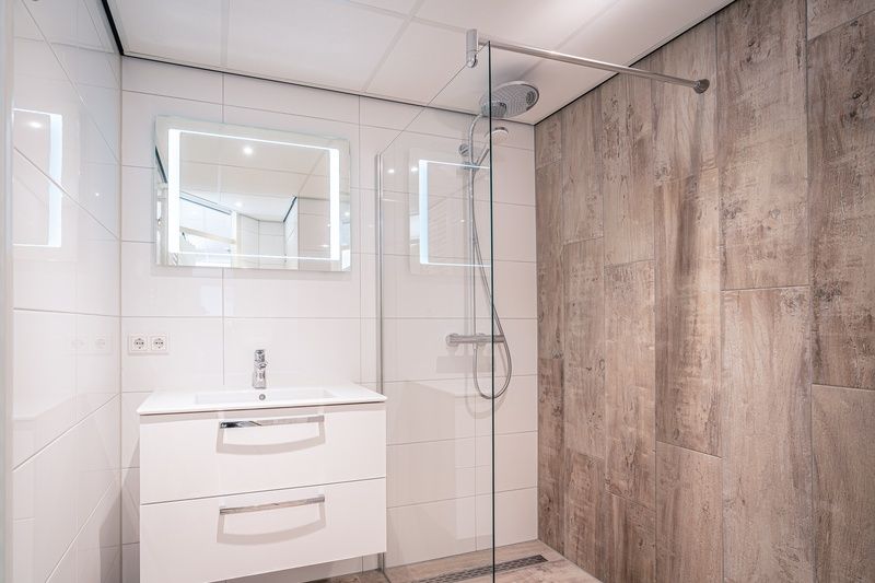 Stilvolles Badezimmer im Apartment Juliana 124 Eilandzicht, De Koog, Texel mit begehbarer Dusche und Waschbecken.