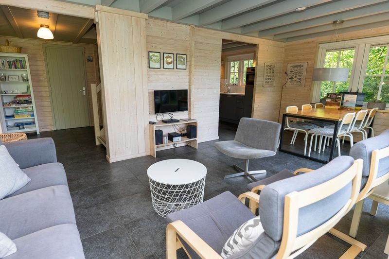 Gezellige binnenruimte van Het Boshuis, Vakantiepark Het Oude Dijkje in De Koog, Texel, met comfortabele zitruimte.