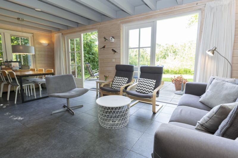 Ruime woonkamer met uitzicht op terras in Het Boshuis, Vakantiepark Het Oude Dijkje, De Koog, Texel.