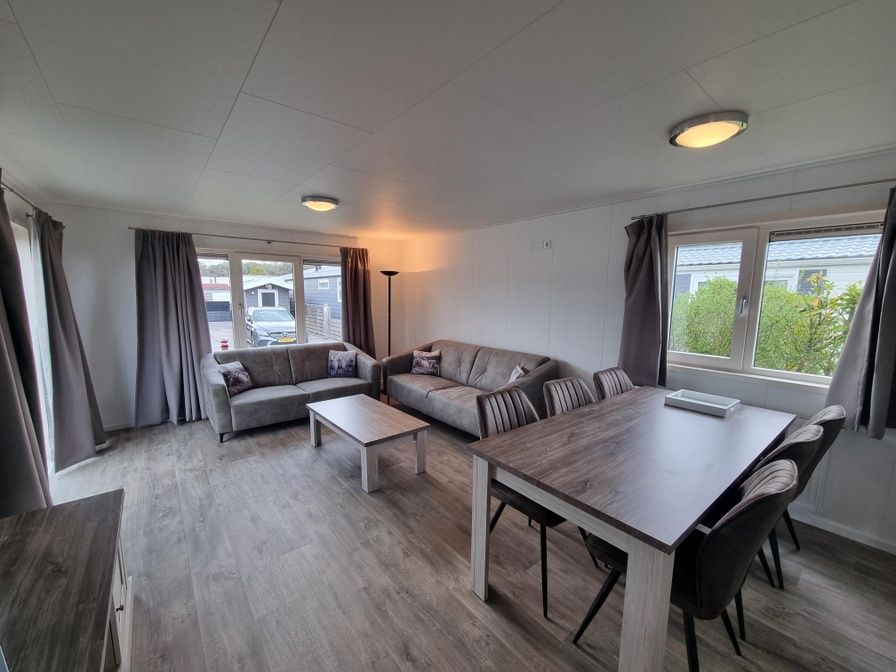 Spacious living room in Chaletpark Bregkoog - Chalet 240 De Texelse Berg, De Koog, Texel with comfortable sitting area and dining area.