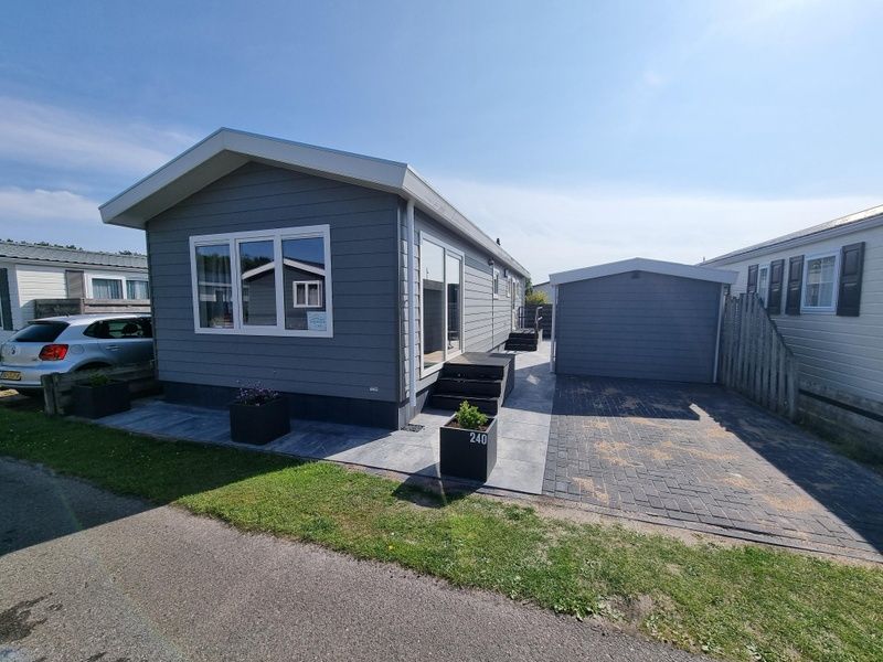 Exterior of Chalet Park Bregkoog - Chalet 240 De Texelse Berg, De Koog, Texel with modern terrace and parking.