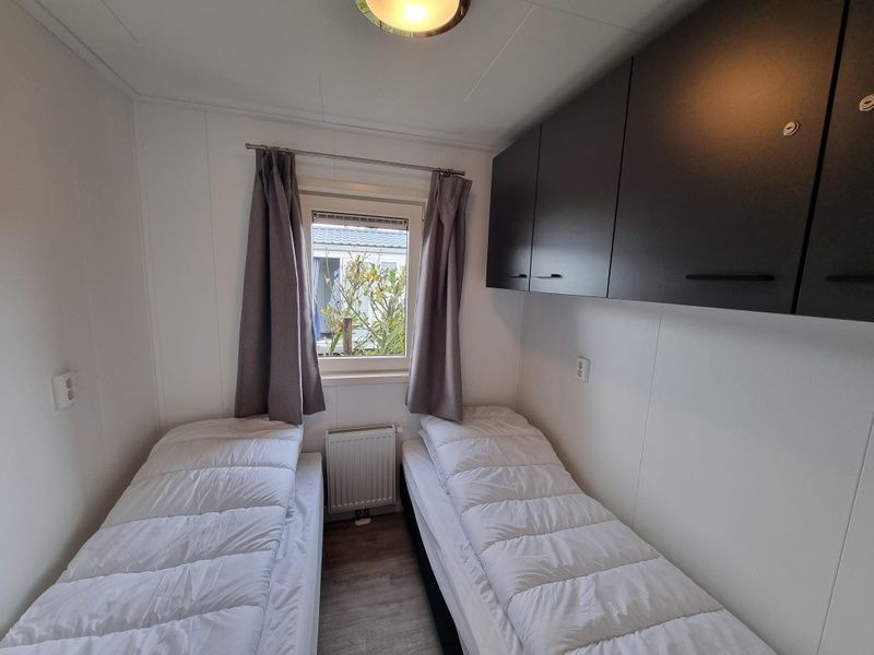 Second bedroom in Chaletpark Bregkoog - Chalet 240 De Texelse Berg, De Koog, Texel with two single beds.