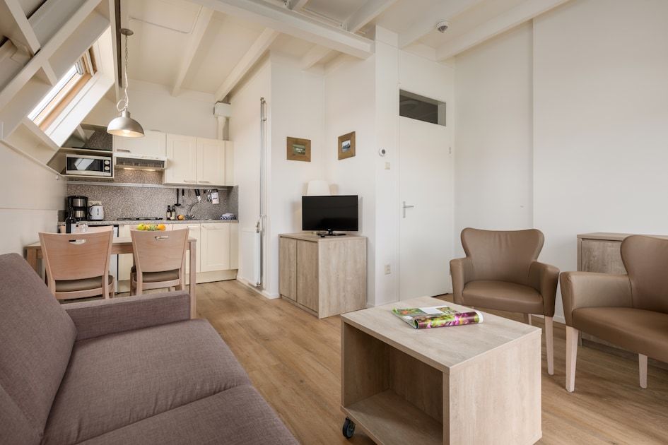 Gezellige woonkamer in C Appartement Comfort 4, De Koog, Texel met moderne keuken en comfortabele zithoek op de Waddeneilanden.