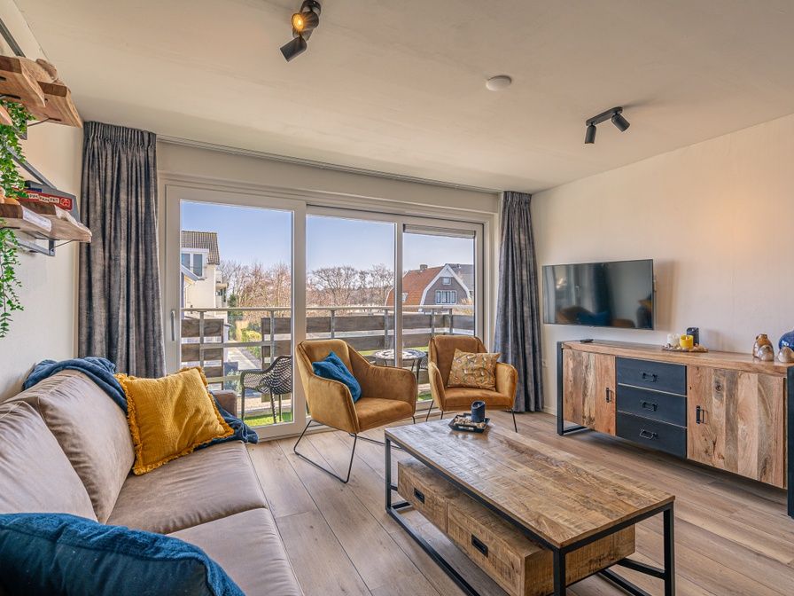 Gezellige woonkamer van Appartement Anna 220 in De Koog, Texel met modern interieur en uitzicht op het terras.