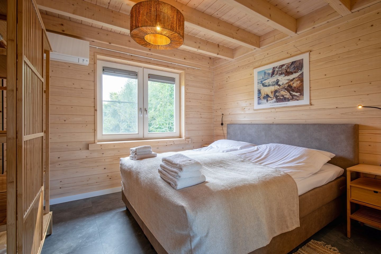 Slaapkamer met houten interieur in De Verleegen Hoek vakantiehuis in De Koog Texel met uitzicht op natuur.
