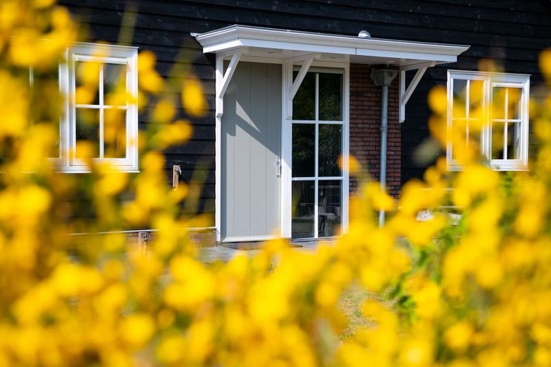 Eingang zur Residenz Rustic holiday home in De Koog, Texel, mit bluehenden Blumen