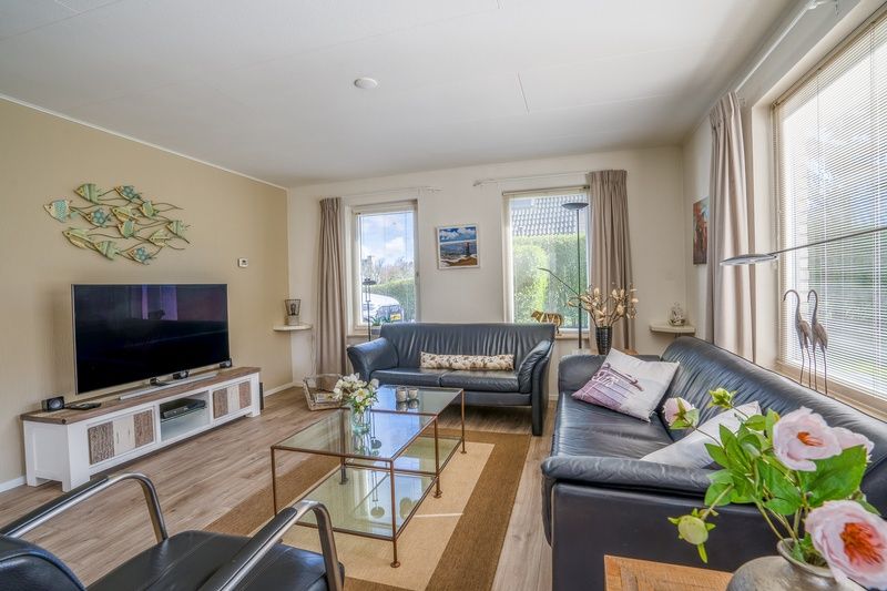 Geraeumige Sitzecke im Ferienhaus Kamperfoelie 91, De Koog, Texel, mit modernen Moebeln und grossen Fenstern.