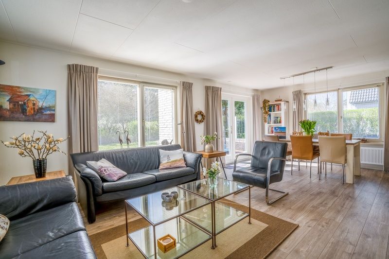 Heller Wohnbereich im Ferienhaus Kamperfoelie 91, De Koog, Texel, mit Essecke und geraeumiger Sitzecke.