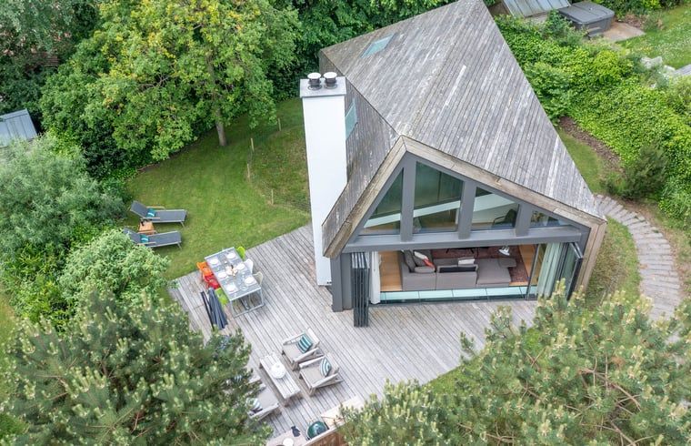 Luftaufnahme des Ferienhauses in De Koog, Texel mit grosser Terrasse und gruener Umgebung, ideal fuer Naturliebhaber auf den Watteninseln.