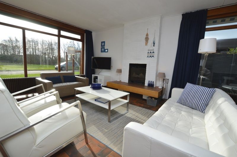 Bright living room in Orchismient 18 large, De Koog, Texel with large windows and elegant interior.